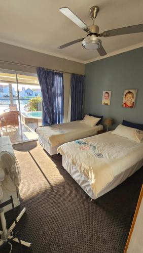 フェルドドリフにあるRiverfront Retreatのベッド2台と天井ファン付きの寝室