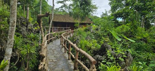 Làng XaにあるHGNI Valley - Thung Lũng Tự Doのジャングルの建物に通じる木製の橋