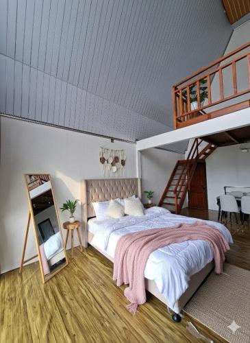a bedroom with a bed and a staircase and a mirror at Villa Castanea Dieng in Diyeng
