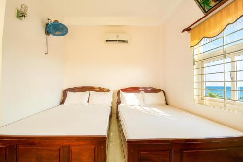 Ly SonにあるHoa Bien Motelの窓のある部屋にベッドが2つある