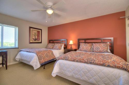 a bedroom with two beds and a ceiling fan at Barefoot Yacht Club Villas - 1-805 in Myrtle Beach