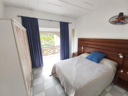 a bedroom with a bed with a blue pillow at Kenville in Cap Malheureux