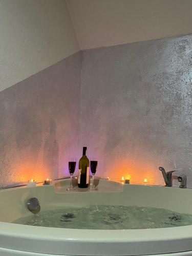 a man sitting in a bath tub with two wine glasses at Pogled na Romaniju in Pale