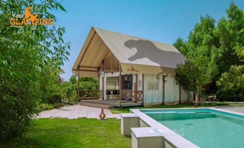 a small house with a swimming pool in front of it at T-Rex Glamping in Dubai