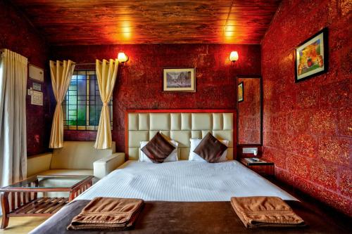 um quarto com uma cama e uma parede vermelha em Rofinos Cottages em Parra