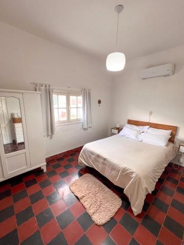 a bedroom with a bed and a checkered floor at Refugio Del Corazón in Capilla del Monte