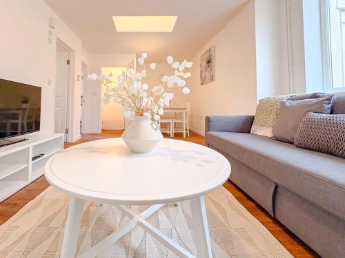 a living room with a white table and a couch at 58b Thorpe Road - City Centre in Norwich