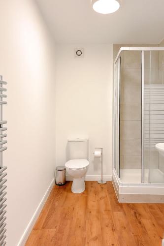 a white bathroom with a toilet and a shower at 58b Thorpe Road - City Centre in Norwich