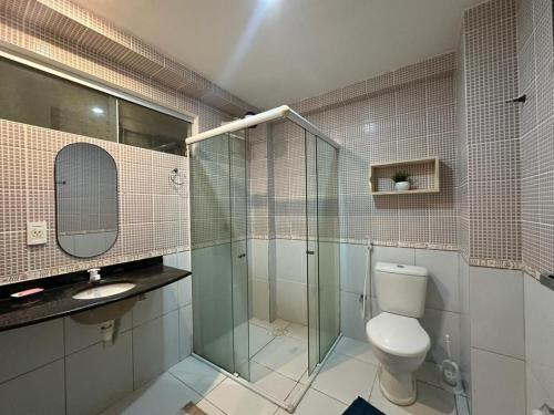 a bathroom with a toilet and a glass shower at Careca’s Beach Flat 302 in Natal