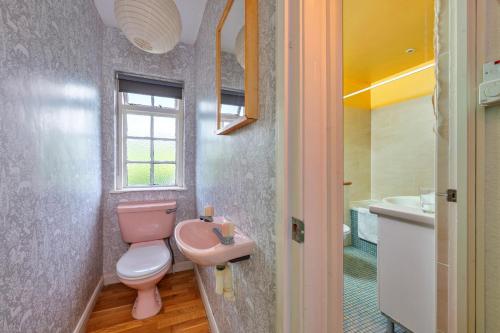 a bathroom with a pink toilet and a sink at Finest Retreats - The Breakers in Poughill