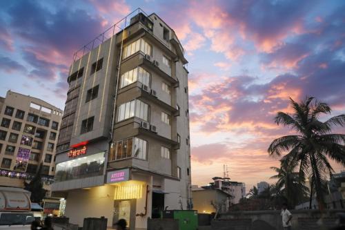 a tall building with a sunset in the background at Atithi Deluxe Rooms in Nale Sopāra