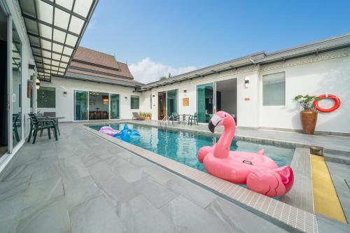 a pool with a pink inflatable flamingo in a house at Phuket La Siesta Pool Villas & Pool Access Rooms in Nai Harn Beach