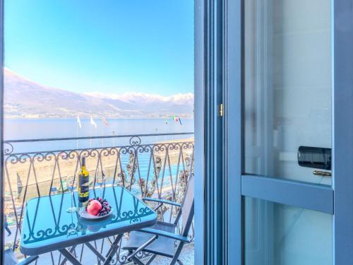 a table with a plate of food on a balcony at Apartment Blue Lake by Interhome in Bellano