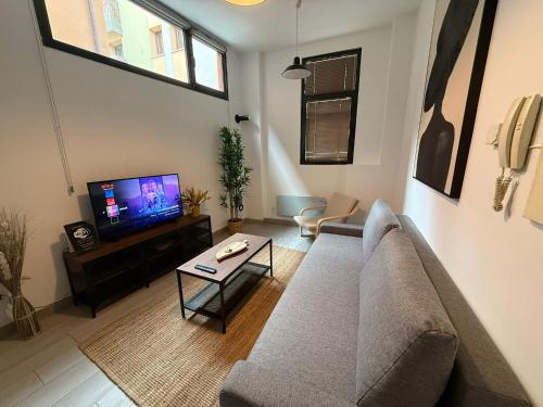 a living room with a couch and a tv at Atuaire Home Mirador de Saldaña en pleno centro Historico in Burgos