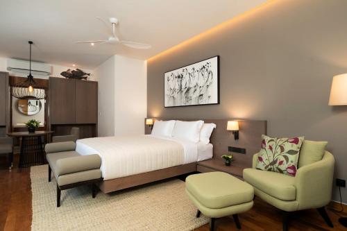 a hotel room with a bed and two chairs at Nyne Hotels Anuprit - Bentota in Bentota
