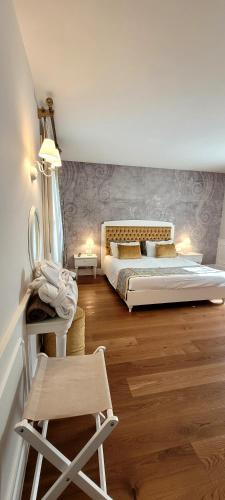 a bedroom with two beds and a chair in it at Relais Althea Azienda Agrituristica in Vittorio Veneto