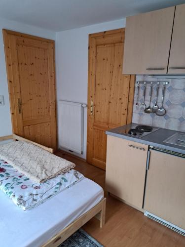 a small kitchen with a bed and a stove at Urlaub am Liasnhof in Bad Aussee