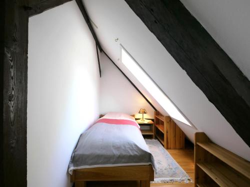 a attic room with a bed and a staircase at Teichblick in Trebel