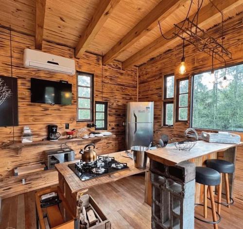 a kitchen with wooden walls and wooden flooring at Cabana na Tree in Urubici