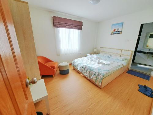 a bedroom with a bed and an orange chair at TD Bangkok in Bangkok