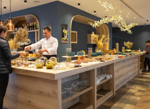 uno chef che prepara il cibo al bancone di un ristorante di Expocore Hotel a Yerevan