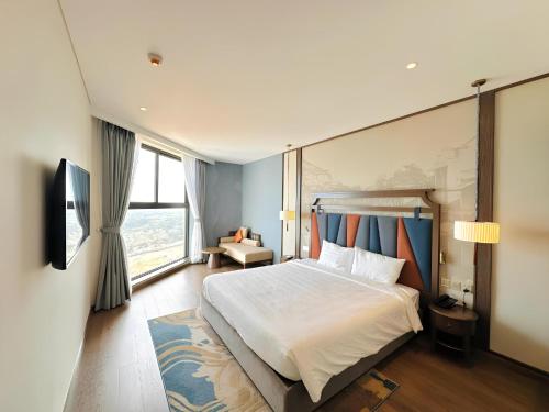une chambre d'hôtel avec un grand lit et une fenêtre dans l'établissement Apec Mandala Wyndham ChamBay Mui Ne - LT, à Ấp Thiẹn Ái