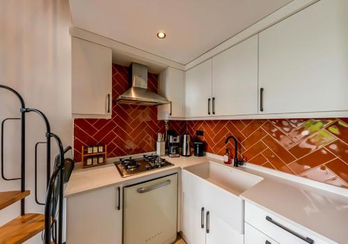 a kitchen with white cabinets and a sink at Sunshine Villa in Atakum