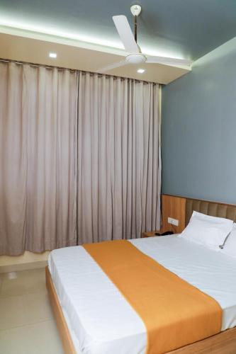 a bedroom with a bed and a ceiling fan at Atithi Deluxe Rooms in Nale Sopāra