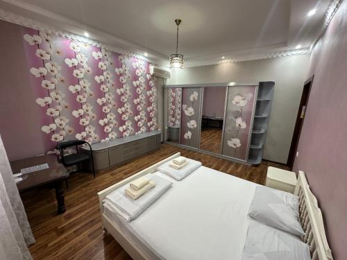 ein Zimmer mit einem Bett und einem Spiegel in der Unterkunft House of Timur in Buxoro