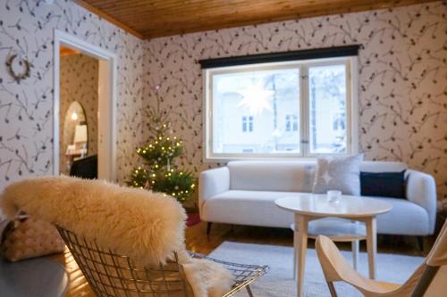 a living room with a couch and a christmas tree at Arctic Garden Design Villa in Rovaniemi