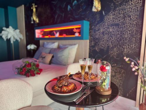 een tafel met twee borden met eten en drinken op een bed bij Flower Suite & Spa, air-conditioned and beach in La Seyne-sur-Mer