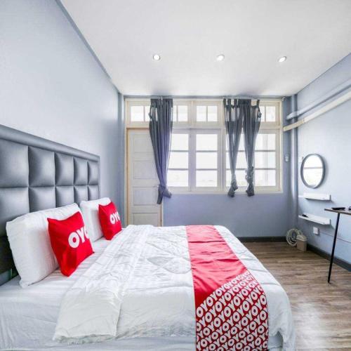 a bedroom with a large bed with red and white pillows at Bossa House Hostel & Cafe in Bangkok