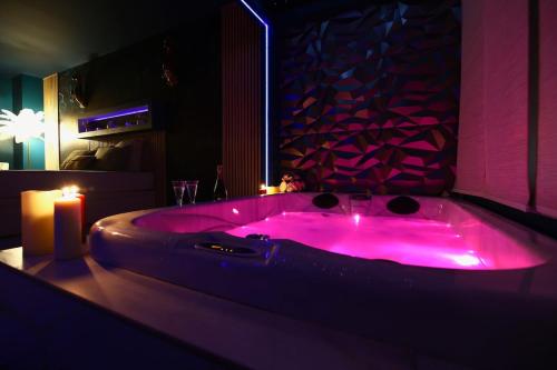 een badkamer met een roze bad met een kaars bij Flower Suite & Spa, air-conditioned and beach in La Seyne-sur-Mer