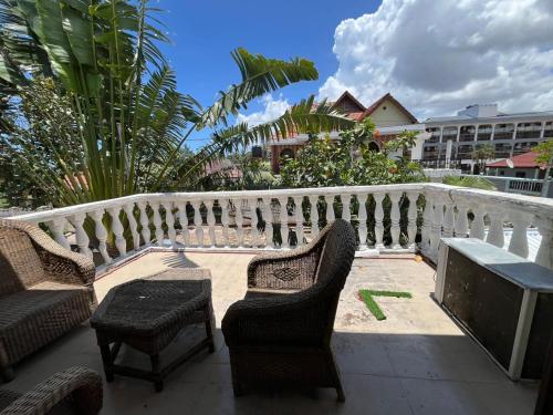 达累斯萨拉姆Home的阳台配有两把椅子、一张桌子和一张长凳