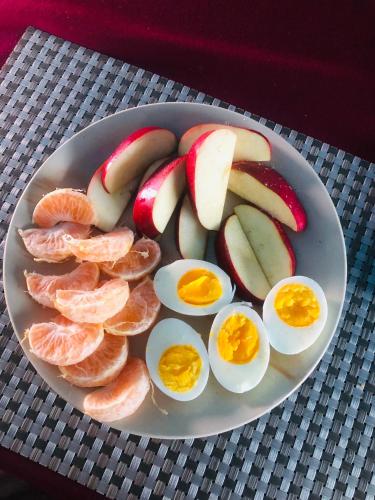 um prato de ovos e frutas sobre uma mesa em Hotel Happy Land em Chitwan
