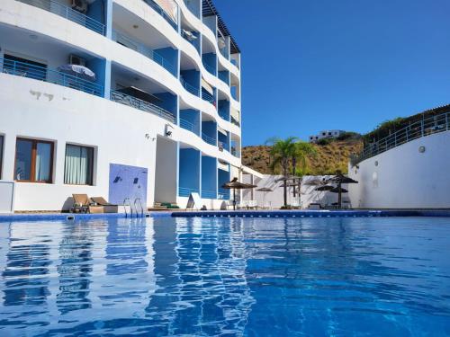a large swimming pool next to a cruise ship at Cabo dream in Cabo Negro
