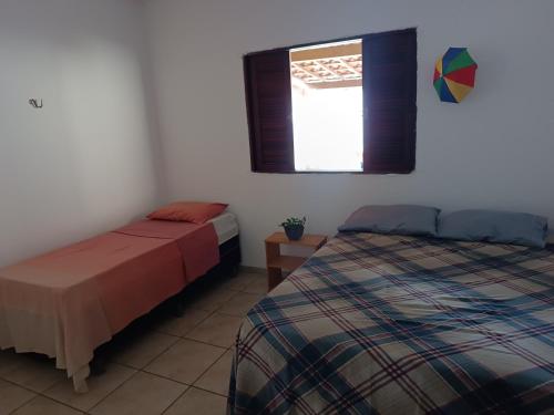 - une chambre avec un lit, une fenêtre et un couvre-lit dans l'établissement Sol guest house, à Pipa