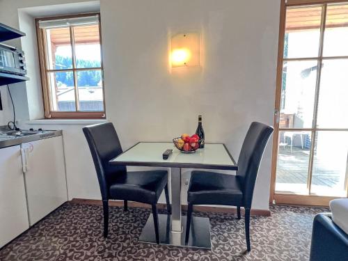 a dining room table with chairs and a bottle of wine at Apartment Cheeky Apartment-6 by Interhome in Oberndorf in Tirol