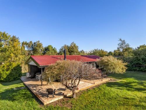 a house with a red roof and a wooden deck at Holiday Home Tameran - 1km from the sea by Interhome in Gedesby