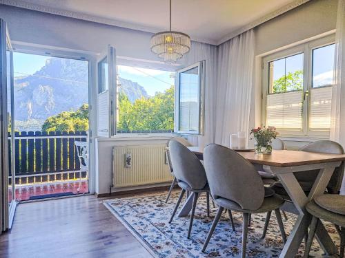 a dining room with a table and chairs and a balcony at Villa Villa Rose by Interhome in Nachdemsee