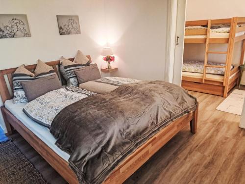 a bedroom with a large bed and two bunk beds at Villa Villa Rose by Interhome in Nachdemsee