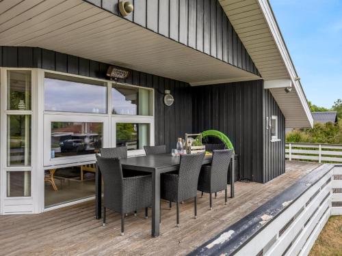 a black house with a table and chairs on a deck at Holiday Home Joonatan - 900m from the sea by Interhome in Hejls