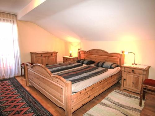 1 dormitorio con 1 cama grande de madera y 2 mesitas de noche en Apartment Plank-1 by Interhome, en Stumm