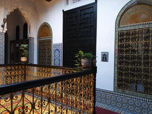 a balcony with a black door and a potted plant at Riad EL Manantial,Dar Hajjaj,Patrimonio del SXIX in Tetouan