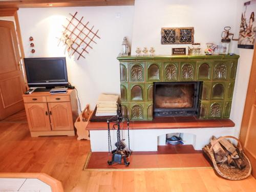 a room with a green fireplace and a television at Apartment Landhaus Weisser by Interhome in Neudingen