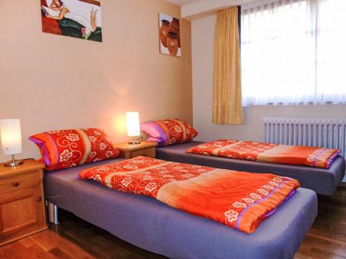 two beds in a room with two lamps and a window at Apartment Landhaus Weisser by Interhome in Neudingen