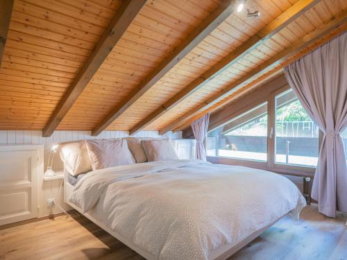 a bedroom with a white bed with a large window at Apartment Centaure B CO 1 by Interhome in Ovronnaz