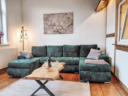 a living room with a green couch and a table at Apartment Schwalenberger Land by Interhome in Schieder-Schwalenberg
