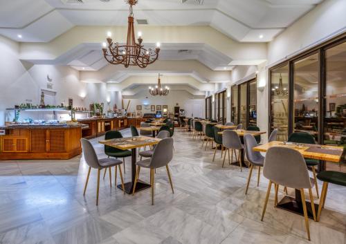 a restaurant with tables and chairs and a bar at AZZ Guadacorte Campo de Gibraltar in Los Barrios