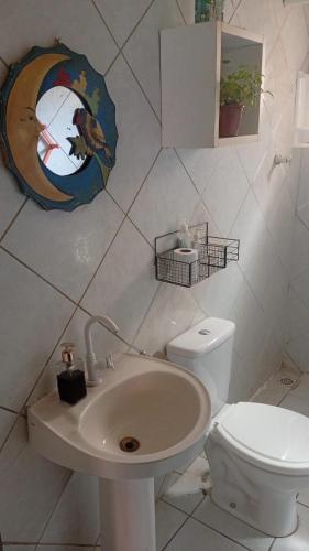 a white bathroom with a toilet and a sink at Sol guest house in Pipa